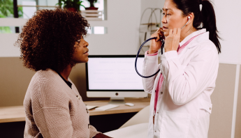 Una médica se reúne con una paciente ante un fondo claro, analizando sus inquietudes y brindándole una atención personalizada y de apoyo.